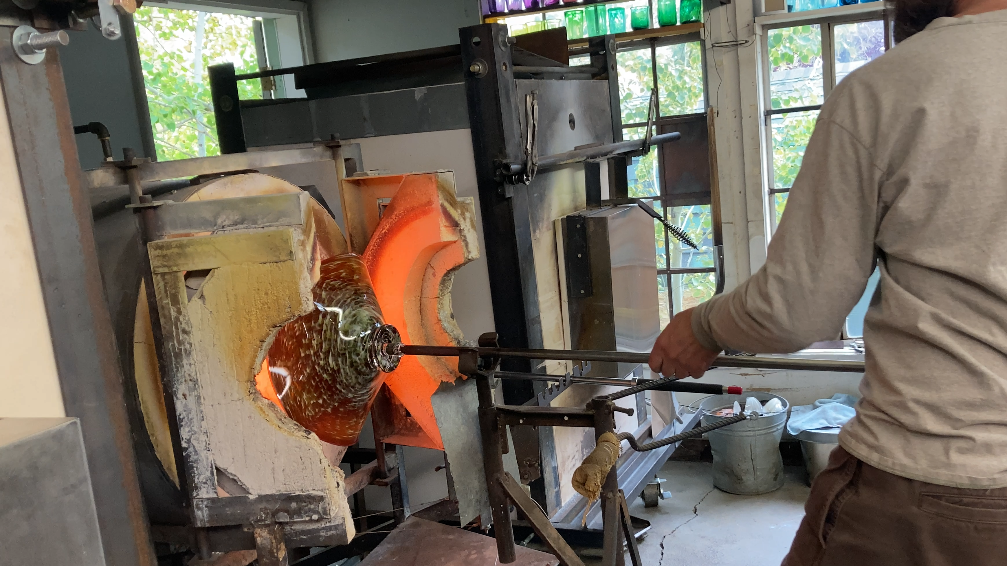 Glassblower working with molten glass in a workshop